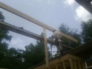 Carpenter setting a ridge beam over a new addition frame — Ice Dam Removal by Roofing Brothers in Sacramento