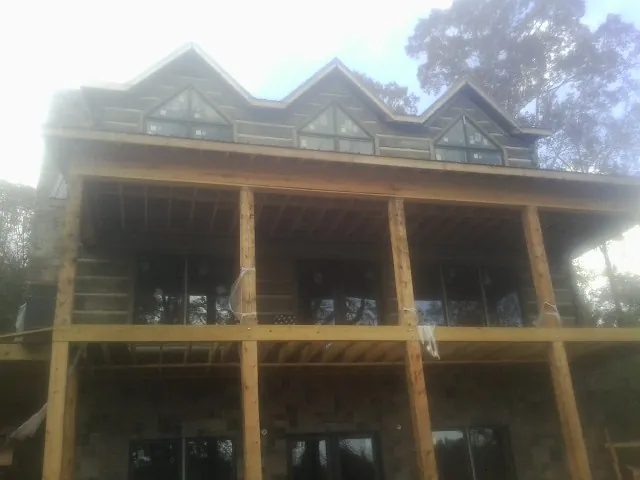 Dormers and porch framing on a large log home under construction — Roof Coating work by our crew in Sacramento